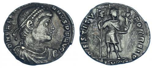 36   -  IMPERIO ROMANO. VALENTINIANO I. Silicua. Lugdunum (364-367). R/ Emperador en traje militar con victoria, lábaro con crismón y gancho en el mástil; RESTITVTOR REIP, exergo (-)LVG. RIC-6. MBC.